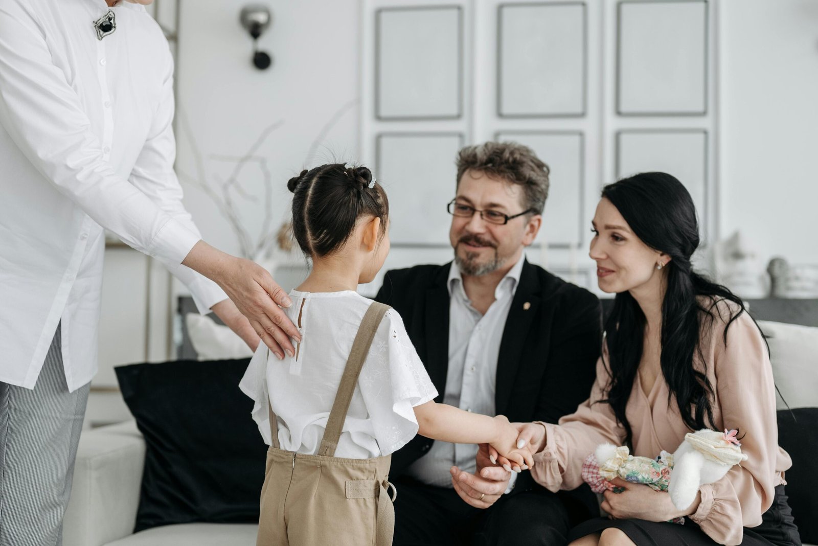 A touching moment between prospective parents and a child at an adoption center indoors.