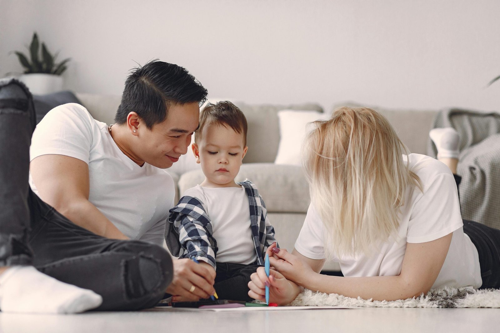 Family enjoying quality time drawing together on the living room floor.